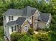 Stately home featuring a stone facade, classic black shutters, and professionally landscaped grounds at 109 San Juan Dr, Chapel Hill, NC 27514