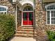 Elegant stone entryway featuring a bright red front door and beautiful landscaping at 109 San Juan Dr, Chapel Hill, NC 27514