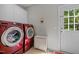 Modern laundry room with red washer and dryer set and access to the outside at 109 San Juan Dr, Chapel Hill, NC 27514