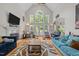 Bright living room with large windows, hardwood floors, and stylish furnishings with a cozy fireplace at 109 San Juan Dr, Chapel Hill, NC 27514