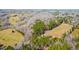 Expansive aerial view showcasing a blend of wooded and open land, highlighting the property's natural surroundings at 1101 Dimmocks Mill Rd, Hillsborough, NC 27278