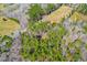 Aerial view of wooded acreage offering privacy and natural beauty with adjacent open land and roadway at 1101 Dimmocks Mill Rd, Hillsborough, NC 27278