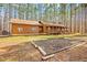 Log cabin with garden and wood shed surrounded by lush greenery and tall trees at 1101 Dimmocks Mill Rd, Hillsborough, NC 27278
