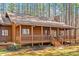 Inviting log cabin with a charming wrap around porch and well manicured landscaping at 1101 Dimmocks Mill Rd, Hillsborough, NC 27278