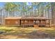 Charming log cabin with a cozy front porch, nestled amongst a backdrop of tall pine trees at 1101 Dimmocks Mill Rd, Hillsborough, NC 27278