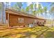 Exterior view of a log cabin style home with a backyard patio surrounded by trees at 1101 Dimmocks Mill Rd, Hillsborough, NC 27278