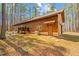 Exterior view of a log cabin style home with a backyard patio surrounded by trees at 1101 Dimmocks Mill Rd, Hillsborough, NC 27278