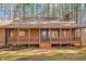 Inviting log cabin features a charming porch with wooden railings and decorative flower pots at 1101 Dimmocks Mill Rd, Hillsborough, NC 27278
