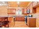 Charming log cabin kitchen with wooden cabinets, modern appliances, and a cozy breakfast bar at 1101 Dimmocks Mill Rd, Hillsborough, NC 27278