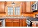 Close-up of log cabin kitchen with wood cabinets, stainless steel appliances, and a double window at 1101 Dimmocks Mill Rd, Hillsborough, NC 27278