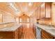 Spacious log cabin kitchen open to living area with wooden cabinets and stainless appliances at 1101 Dimmocks Mill Rd, Hillsborough, NC 27278