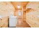 Well-lit laundry room featuring natural wood walls and flooring, plus a washer and dryer hookup at 1101 Dimmocks Mill Rd, Hillsborough, NC 27278