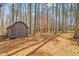 Wooden outdoor shed surrounded by trees, providing ample storage space in wooded backyard at 1101 Dimmocks Mill Rd, Hillsborough, NC 27278