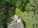 Overhead view of backyard featuring a paver patio, deck, and fire pit area amidst green trees at 111 Canberra Ct, Cary, NC 27513