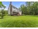 Spacious backyard with a deck, lush lawn, mature trees, and a multi-story home at 111 Canberra Ct, Cary, NC 27513