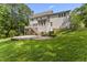 Beautiful backyard with a stone patio surrounded by lush green grass and mature trees at 111 Canberra Ct, Cary, NC 27513