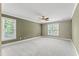Spacious bedroom featuring plush carpeting, a ceiling fan, and natural light from the windows at 111 Canberra Ct, Cary, NC 27513