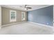 Bright and airy bedroom with neutral walls, plush carpeting, ceiling fan, and lots of natural light at 111 Canberra Ct, Cary, NC 27513