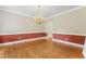 A dining room with hardwood floors, wainscoting, a chandelier, and fresh paint at 111 Canberra Ct, Cary, NC 27513