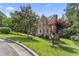 Beautiful brick home surrounded by lush greenery, mature trees, and a well-maintained yard at 111 Canberra Ct, Cary, NC 27513