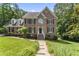 Beautiful two-story brick home with manicured lawn, lush landscaping, and a welcoming pathway at 111 Canberra Ct, Cary, NC 27513