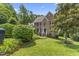 Charming brick home featuring well-manicured landscaping, a lush green lawn, and mature trees at 111 Canberra Ct, Cary, NC 27513