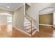 Foyer with hardwood floors, staircase with wooden handrail, and archway leading to another room at 111 Canberra Ct, Cary, NC 27513