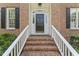 Classic brick home entrance featuring a black front door and white railing stairs with brick steps at 111 Canberra Ct, Cary, NC 27513