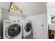 Convenient laundry room with modern washer and dryer, ample storage, and a window for natural light at 111 Canberra Ct, Cary, NC 27513