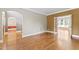 Living room with hardwood floors and view into another room through an archway and glass doors at 111 Canberra Ct, Cary, NC 27513