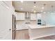 A well-lit kitchen features an island with stainless steel appliances and white cabinets at 1194 Alston Landing Way # 04, Cary, NC 27519