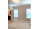Bright bedroom with neutral carpet features an ensuite bathroom and windows for natural light at 1205 Capstone Dr, Durham, NC 27713
