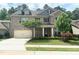 Charming two-story brick home featuring a two-car garage, well-manicured lawn, and inviting front porch at 1205 Capstone Dr, Durham, NC 27713