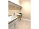 Functional laundry room offers a sink, cabinet, and storage shelf with granite tile floors at 1205 Capstone Dr, Durham, NC 27713