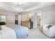 This main bedroom features a tray ceiling, a modern chandelier, a neutral color palette, and ensuite bathroom access at 1219 Everton Ave, Durham, NC 27703