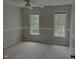 Neutral bedroom with a ceiling fan and two windows offering natural light and outdoor views at 133 Rustic Ln, Smithfield, NC 27577