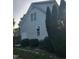 Side view of the house with vertical siding, windows, and mature landscaping at 133 Rustic Ln, Smithfield, NC 27577