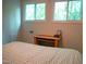 Bedroom with a bed and desk featuring two windows offering views of the surrounding trees at 1423 Alderman Cir, Raleigh, NC 27603