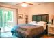 Bright bedroom with a dark wood headboard, and a sliding door to the outdoor deck at 1423 Alderman Cir, Raleigh, NC 27603