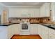 Bright kitchen features white cabinets, a tile backsplash, and stainless steel appliances at 1749 Conners Ct, Burlington, NC 27215