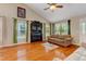 Bright living room with hardwood floors, a fireplace, and large windows with green curtains at 1749 Conners Ct, Burlington, NC 27215