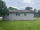 Rear view of a single-story house featuring light siding and green grass at 1851 S Clearview Dr, Henderson, NC 27536