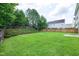 This expansive backyard features a lush lawn, bordered by a wooden fence and mature trees, offering privacy and a natural backdrop at 201 Masterwood Way, Morrisville, NC 27560