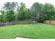 A vast backyard with a lush lawn, wooden fence, and mature trees offers serene privacy and a picturesque natural backdrop at 201 Masterwood Way, Morrisville, NC 27560