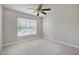 Cozy bedroom featuring a ceiling fan, bright window, neutral color palette, and carpeted floors at 201 Masterwood Way, Morrisville, NC 27560