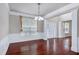 Bright dining room featuring hardwood flooring, windows, wainscoting, columns, and light fixture at 201 Masterwood Way, Morrisville, NC 27560