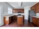 Updated kitchen with wood cabinets, tile backsplash, an island, and stainless steel refrigerator at 201 Masterwood Way, Morrisville, NC 27560