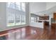 Open-concept living room with hardwood floors, large windows, and kitchen access at 201 Masterwood Way, Morrisville, NC 27560