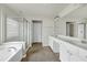Well-lit bathroom featuring a dual sink vanity, tiled floors, and glass enclosed shower at 201 Masterwood Way, Morrisville, NC 27560