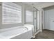 Bright bathroom featuring a soaking tub and separate glass enclosed shower under a window at 201 Masterwood Way, Morrisville, NC 27560